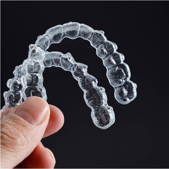 Clear removable aligner trays held in a hand
